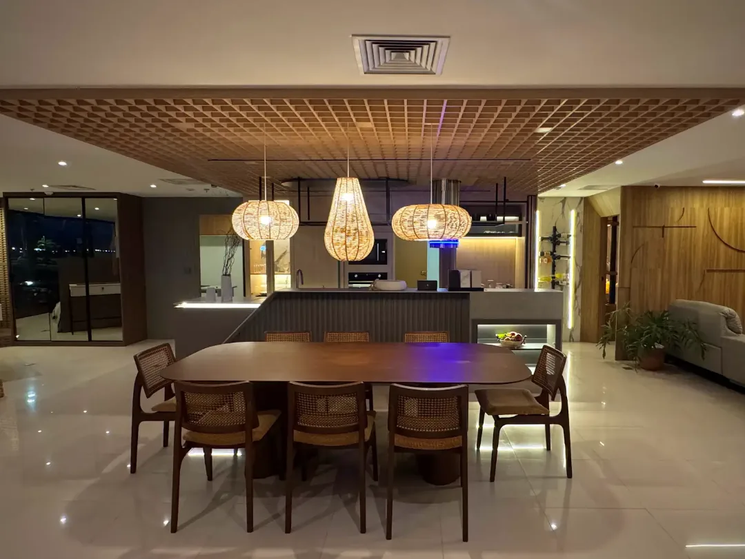 Sala de jantar integrada com painéis de madeira e iluminação pendente